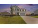 Beautiful home with a white exterior, a well-kept lawn, and a serene sunset backdrop at 715 Mcroy St, Moncks Corner, SC 29461