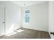 A minimalistic empty bedroom with neutral carpet, white walls, and natural light at 816 Gentle Breeze Dr, Summerville, SC 29486