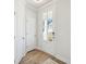 Bright entryway featuring hardwood flooring, a glass-panel door, and white walls, creating a clean, modern aesthetic at 827 Alma Square Dr, Moncks Corner, SC 29461
