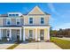 Charming townhome showcasing a well-maintained front yard, covered entry, and a modern architectural design under a clear blue sky at 827 Alma Square Dr, Moncks Corner, SC 29461