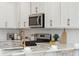 Close-up of the kitchen featuring stainless steel appliances, white cabinetry, and a gold faucet at 827 Alma Square Dr, Moncks Corner, SC 29461