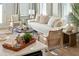 Inviting living room with a white sofa, wicker chairs, and modern decor, adjacent to a white kitchen at 827 Alma Square Dr, Moncks Corner, SC 29461