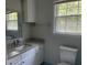 Bright bathroom with granite counters, white cabinetry, and updated fixtures at 8392 Herbert Smalls Rd, Edisto Island, SC 29438