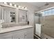 Bathroom with double sinks, modern mirrors, and a shower with glass door at 8524 Belford Ct, North Charleston, SC 29420