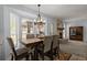 Bright dining area features large windows, wood table with six chairs, and an elegant chandelier at 8524 Belford Ct, North Charleston, SC 29420