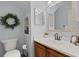 Powder room featuring white countertop, dark cabinets, modern sink, and decorative wreath at 8524 Belford Ct, North Charleston, SC 29420