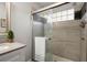 Contemporary shower with tiled walls, glass door, and natural light from a small window at 8524 Belford Ct, North Charleston, SC 29420
