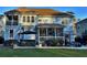 Back of light blue home featuring a spacious screened porch, a hot tub and a well-maintained yard at 855 Hunt Club Run, Charleston, SC 29414