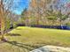 Spacious, fenced backyard with lush green lawn and mature trees, perfect for outdoor activities and relaxation at 855 Hunt Club Run, Charleston, SC 29414