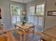 Bright dining area featuring natural light from large windows and a wooden table with white chairs and bench at 855 Hunt Club Run, Charleston, SC 29414