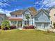 Charming two-story home with light blue siding, a well-manicured lawn, and a welcoming front porch at 855 Hunt Club Run, Charleston, SC 29414