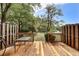 Inviting wooden deck with outdoor seating, offering serene views of the lush backyard and pond with fountain at 880 Simpkins St # 2, Charleston, SC 29412