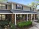 Charming townhome featuring a brick facade, covered porch, manicured landscaping and classic shutters at 880 Simpkins St # 2, Charleston, SC 29412