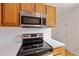 Kitchen featuring wood cabinets, stainless steel microwave, and black electric stovetop at 880 Simpkins St # 2, Charleston, SC 29412