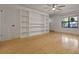 Bright living room featuring built-in shelving, hardwood floors, a modern ceiling fan and natural light at 880 Simpkins St # 2, Charleston, SC 29412