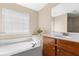 Bright bathroom featuring a soaking tub, vanity with storage, and a large window at 9226 Southern Oak Ln, Ladson, SC 29456