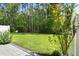 Beautiful backyard featuring a spacious lawn, mature trees, and lush landscaping at 9428 Sweep Dr, Summerville, SC 29485