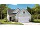 Charming home featuring mint green siding, stone accents, black door and a two-car garage, all surrounded by a lush, well-maintained lawn at 1016 Sagegrass St, Summerville, SC 29485