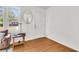 Cozy living area featuring hardwood floors, a white wall, a mirror, and a table with a lamp by the window at 105 Dalton Ave, North Charleston, SC 29420
