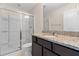 Bathroom featuring granite countertop, dark wood cabinetry, and tiled shower with glass door at 1086 Lexi Ct, Ladson, SC 29456