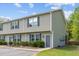 Townhouse with olive green siding and dark shutters complemented by lush green grass and tasteful landscaping at 1086 Lexi Ct, Ladson, SC 29456