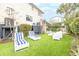 Well-manicured backyard with white outdoor lounge furniture, manicured landscaping and artificial grass at 109 Carolina Blvd, Isle of Palms, SC 29451