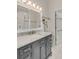 Bathroom boasts a gray vanity with marble countertop, large mirror, and white-tiled flooring at 109 Carolina Blvd, Isle of Palms, SC 29451