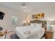 Bedroom showcases white bedding, floral artwork, ceiling fan, and an abundance of natural light at 109 Carolina Blvd, Isle of Palms, SC 29451