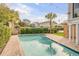 Backyard pool with brick patio, privacy landscaping, overhead string lights, and palm trees at 109 Carolina Blvd, Isle of Palms, SC 29451