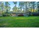Brick home surrounded by a spacious lawn and towering pine trees, creating a peaceful and private outdoor environment at 112 Furlong Rd, Summerville, SC 29483