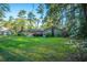 View of a well-maintained, brick home with a large yard and mature trees, offering privacy and a serene outdoor space at 112 Furlong Rd, Summerville, SC 29483