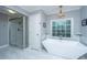 Elegant bathroom with white marble floors, a glass enclosed shower, and a modern standalone tub under a window at 112 Furlong Rd, Summerville, SC 29483
