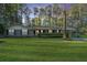 Charming brick home boasts a well-manicured lawn and mature trees at sunset at 112 Furlong Rd, Summerville, SC 29483