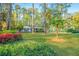 Quaint, brick home on a lush green lawn with mature trees and blooming bushes at 112 Furlong Rd, Summerville, SC 29483