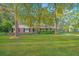 Traditional brick home featuring a spacious yard, carport, and mature trees at 112 Furlong Rd, Summerville, SC 29483