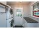 Laundry room with stacked washer and dryer, window, and countertop with storage at 112 Furlong Rd, Summerville, SC 29483