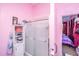 Bathroom with a glass-enclosed shower, white shelving, and pink walls at 11341 Cottageville Hwy, Cottageville, SC 29435