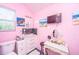 Small pink bathroom with a vanity, toilet, window, and modern décor at 11341 Cottageville Hwy, Cottageville, SC 29435