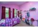 Bright bedroom features pink walls, a patterned bedspread, and natural light from multiple windows at 11341 Cottageville Hwy, Cottageville, SC 29435