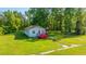 Charming cottage-style home with red deck, surrounded by lush greenery and a well-maintained lawn at 11341 Cottageville Hwy, Cottageville, SC 29435