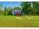 Charming home featuring a red deck, lush lawn, and convenient walkway to the entrance at 11341 Cottageville Hwy, Cottageville, SC 29435