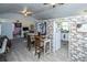 Living room with an adjacent dining area, an open doorway, and stone wall paneling at 11341 Cottageville Hwy, Cottageville, SC 29435