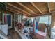 Cluttered, screened in porch featuring wood-paneled walls, a variety of furniture, and storage items at 11341 Cottageville Hwy, Cottageville, SC 29435