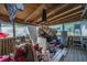 Cluttered, screened in porch featuring wood-paneled walls, a variety of furniture, and storage items at 11341 Cottageville Hwy, Cottageville, SC 29435