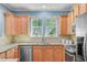 Bright kitchen featuring stainless appliances, tan cabinets, granite countertops, and a view of the backyard at 1215 Dingle Rd, Mount Pleasant, SC 29466