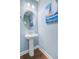 Charming powder room with a pedestal sink, round mirror, and nautical-themed artwork at 1215 Dingle Rd, Mount Pleasant, SC 29466