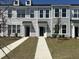 View of townhomes with individual walkways, dark front doors, and neatly landscaped yards at 123 Brown Swiss Cir, Summerville, SC 29483