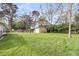 Expansive backyard featuring green grass with a shed and a house, enclosed by leafy trees at 1239 Old Orchard Rd, Charleston, SC 29412
