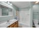 Bathroom features a vanity with wood cabinetry, and a shower-tub combo at 1239 Old Orchard Rd, Charleston, SC 29412