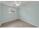 This bedroom features a window, a ceiling fan, and light gray wood floors at 1239 Old Orchard Rd, Charleston, SC 29412